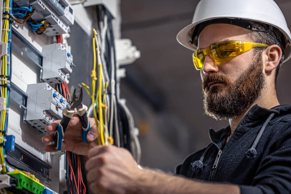 homem trabalhando em um painel elétrico industrial